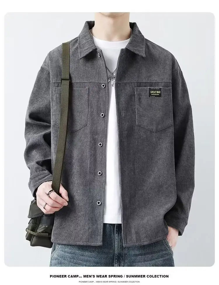 Herren Cordhemd im Casual-Stil mit Langarm in Dunkelgrau mit Knopfverschluss-Design, Kragen und einer Brusttasche, die mit einem schwarzen Great-War-Patch verziert ist.