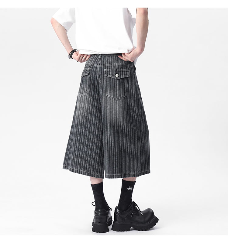 Black and white vertically striped wide-leg denim capri shorts with a buttoned front pocket.