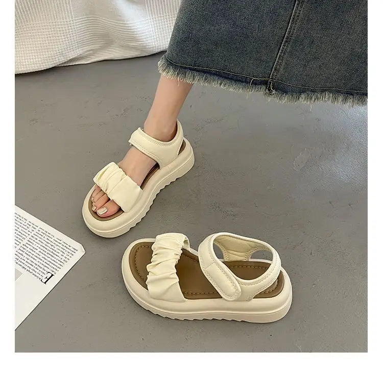 Sandales plateforme couleur crème pour femmes présentant des brides en tissu froncées et une assise plantaire rembourrée avec semelles épaisses.