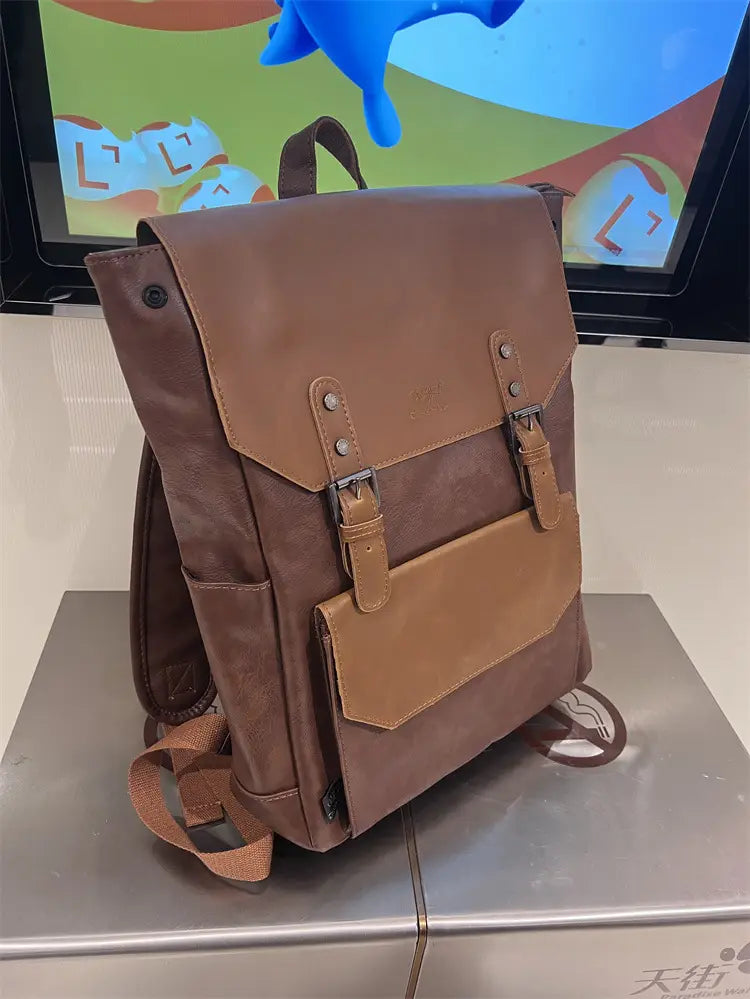Brown leather college backpack with tan accents and metal buckles featuring large capacity for travel and vintage style.