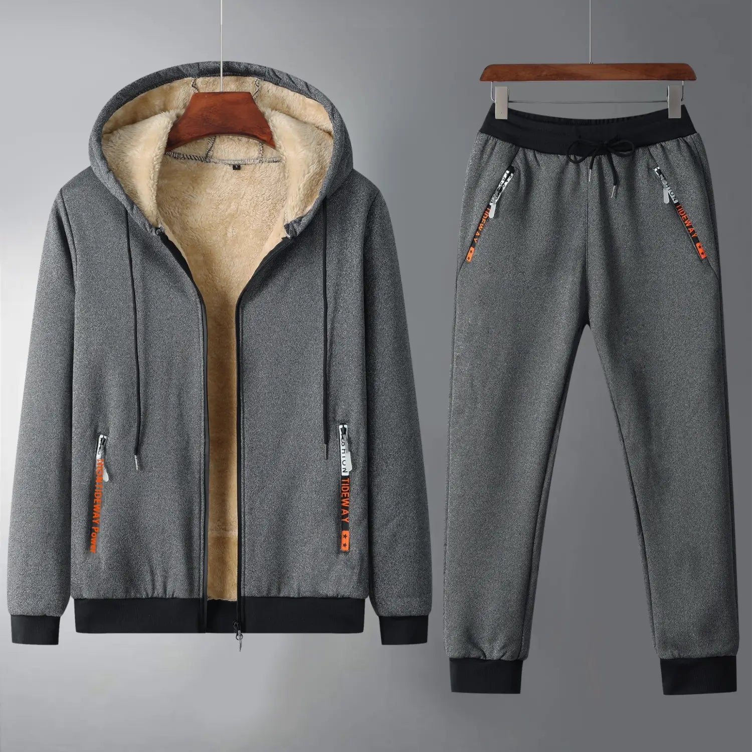 Men fleece lined tracksuit set featuring a gray fleece lined hooded sweatshirt with black trim and orange zipper pulls paired with matching gray joggers.