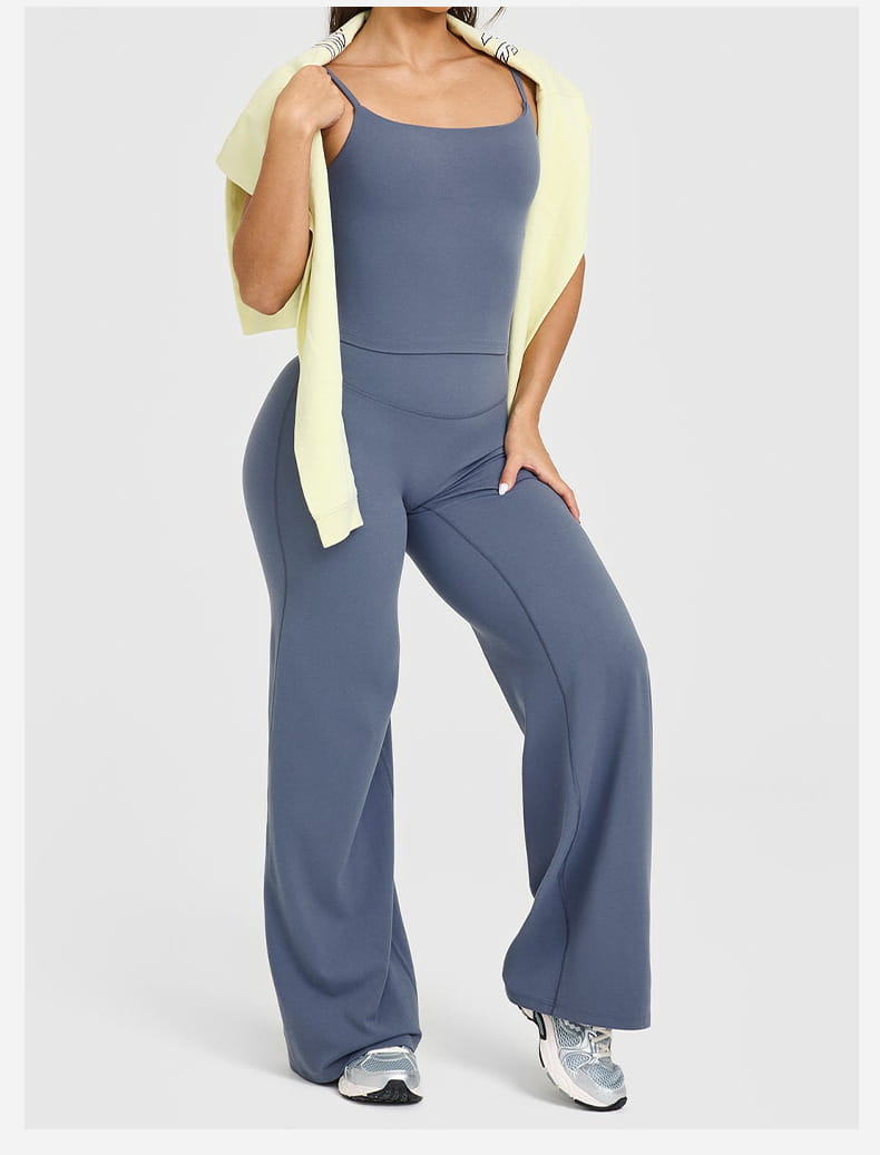 A sleek slate blue stretchy jumpsuit with a square neckline and wide-leg pants designed as slimming high waisted straight leg yoga pants.