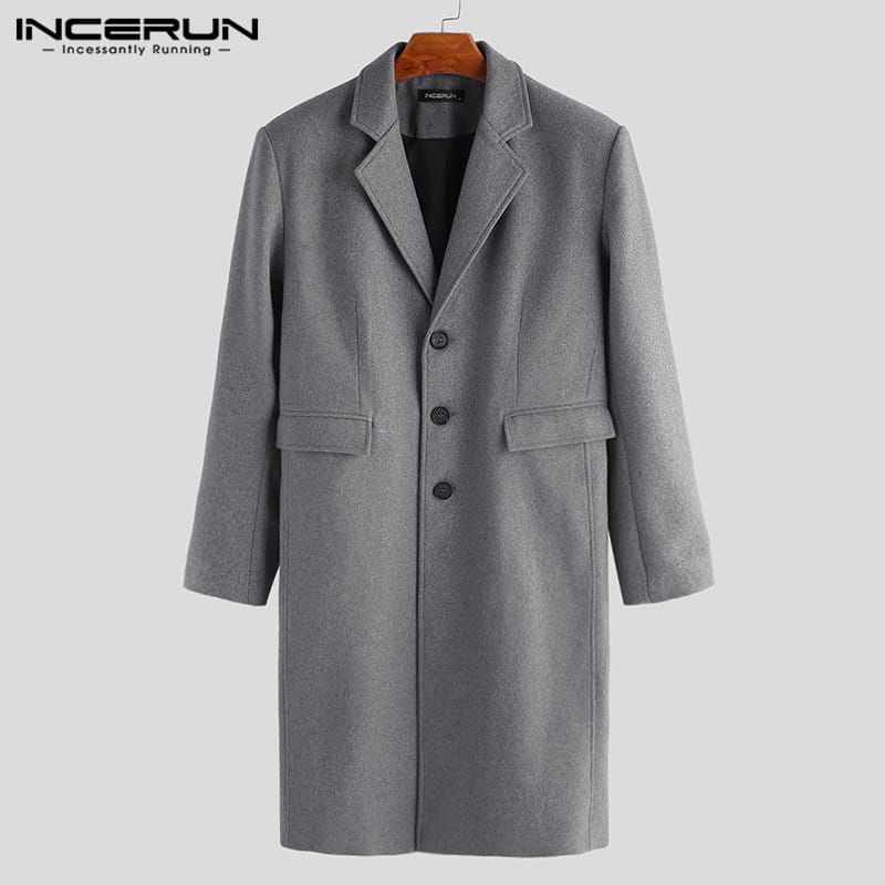 Men’s wool trench coat classic double breasted overcoat in gray wool with a notched collar and three dark buttons hanging on an orange wooden hanger.