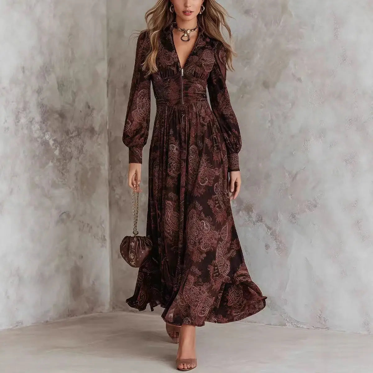 Une robe maxi marron fluide à manches longues, avec un motif cachemire complexe et une taille ajustée, idéale pour des occasions inspirées du style rétro.