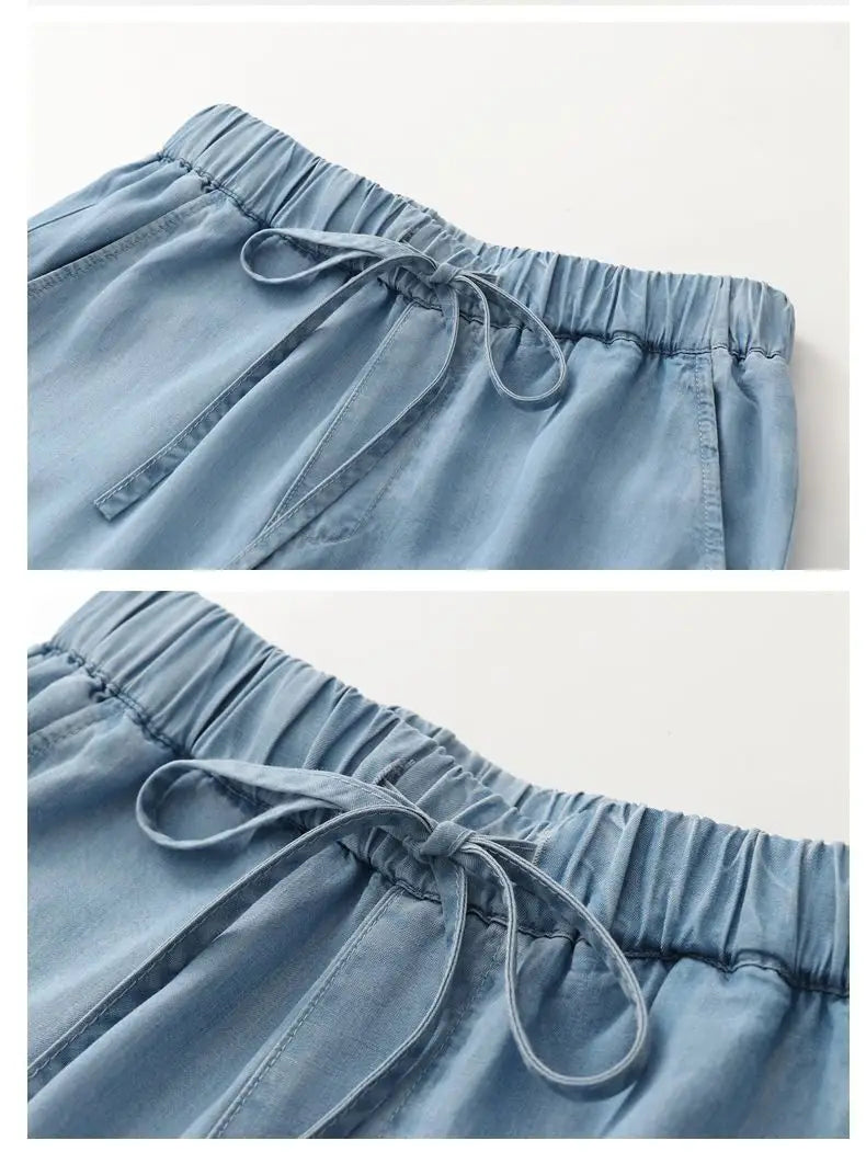 Light blue denim harem jeans high waisted drawstring pants featuring an elastic waistband and matching drawstring.