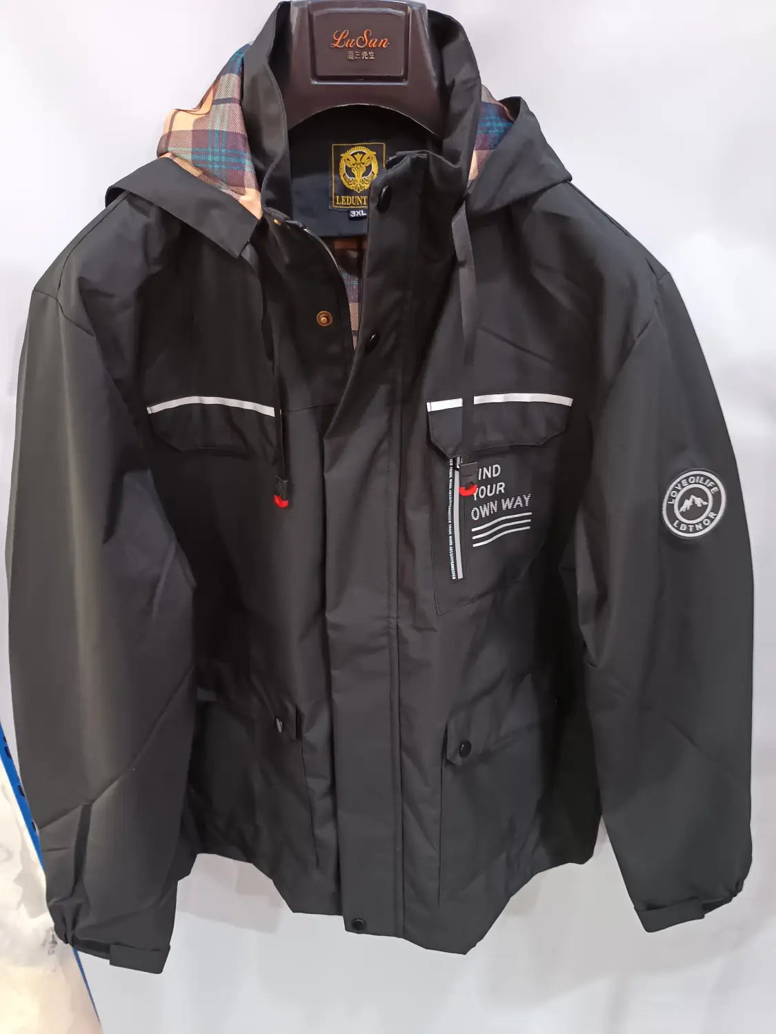 Men winter hooded parka coat in black waterproof fabric with plaid-lined hood white stripe accents and find your own way text on the chest
