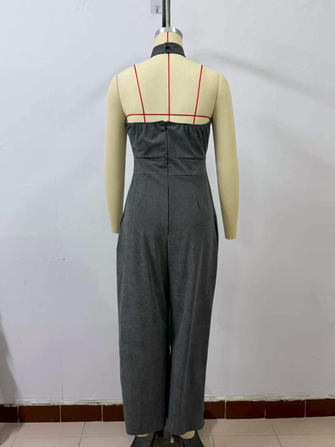 Ein eleganter Jumpsuit aus dunkelgrauem Wollgemisch mit Halterneck, tailliertem Oberteil und Hosen im weitem Bein.