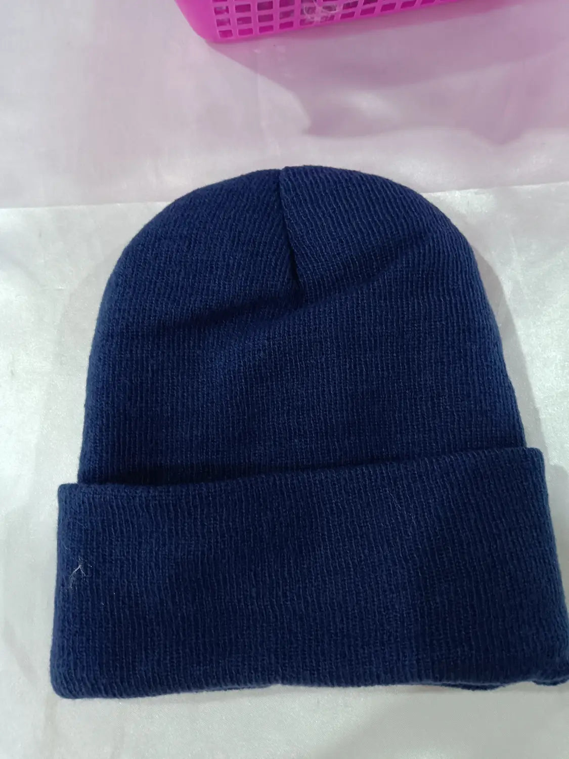 Navy blue ribbed knit satin lined beanie with a folded cuff designed as a warm winter hat.