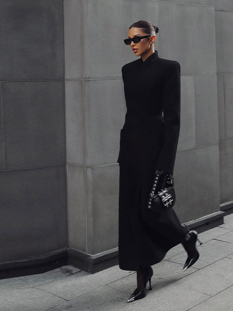 Black structured handbag with silver-tone hardware and studded detailing shown with charcoal gray wool coat women waisted long outerwear.