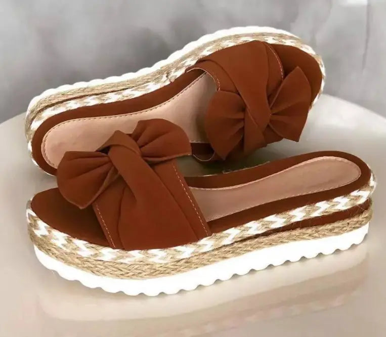 Women platform bow espadrille slide sandals in brown suede with a woven sole and decorative bow.