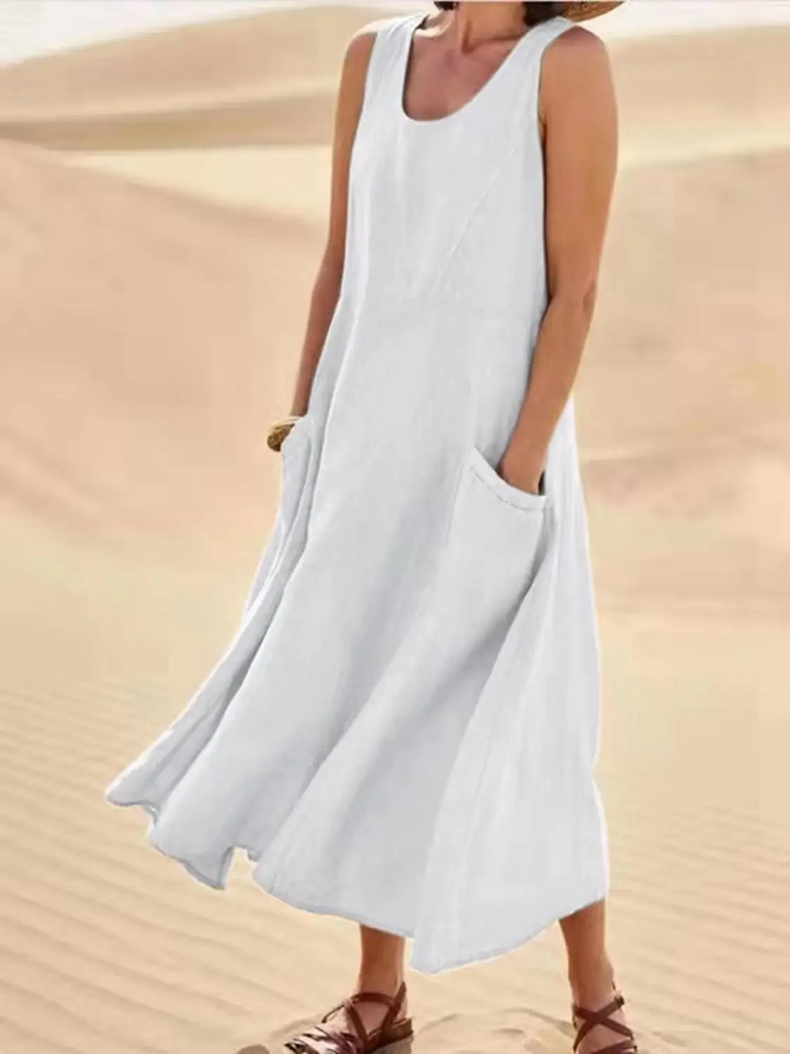 Robe longue maxi en lin blanc sans manches, fluide, coupe trapèze en A, à la coupe ample et avec de grandes poches avant.