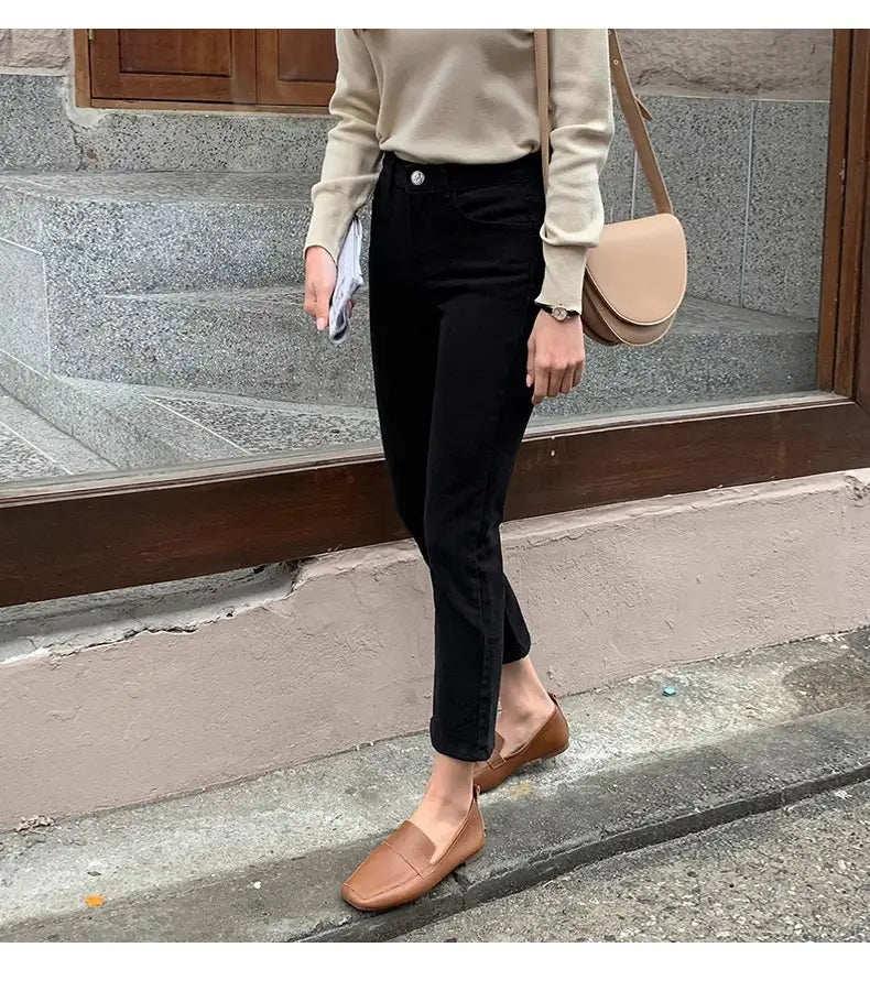 Tane Lederschlupflοafer mit einfachem Schlupfdesign, kombiniert mit schwarzen Samtgefütterten High-Waist-Jeans-Leggings.