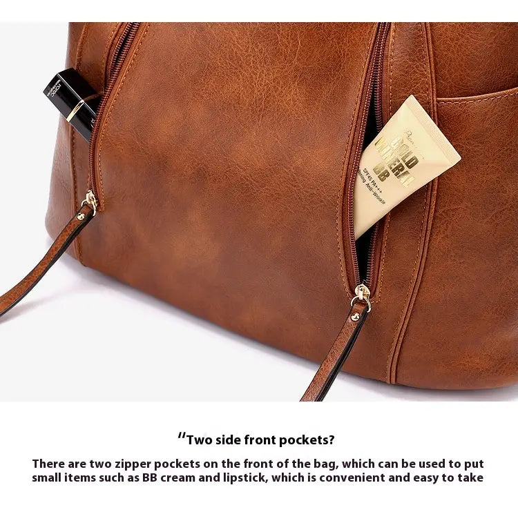 brown leather hobo bag with tassel and two zipper front pockets shown from the front