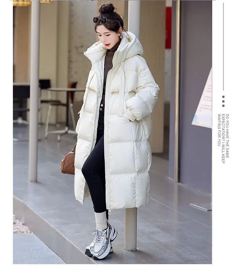Women long hooded puffer coat in off-white quilted fabric with a high collar and elasticized cuffs.