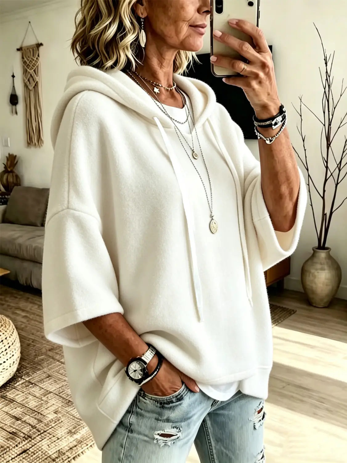 white oversized fleece hooded top with three-quarter sleeves featuring a soft cozy texture and relaxed fit.