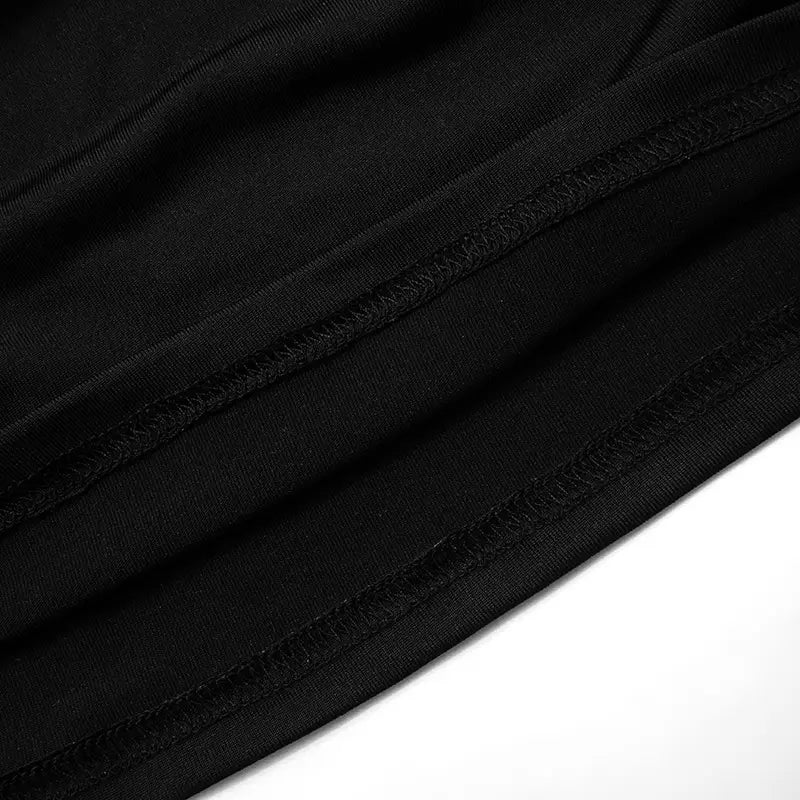 Black fabric with smooth texture and neatly stitched seams of a strapless keyhole crop top.