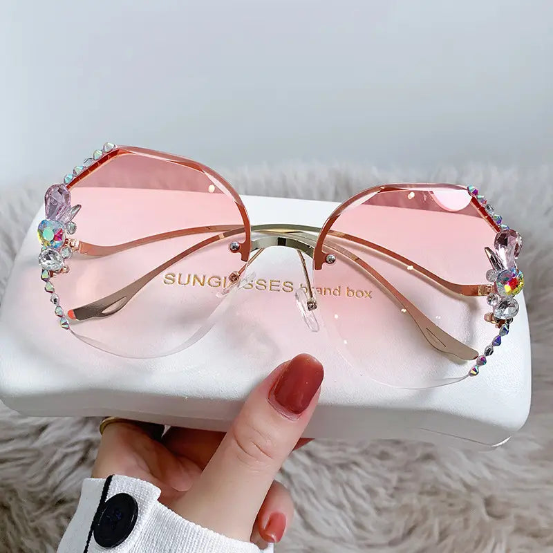 Gafas de sol de lujo con pedrería de mariposa tipo cristal y protección UV400, con lentes degradadas en color rosa, monturas en tono dorado adornadas con brillantes pedrerías y gemas de colores.