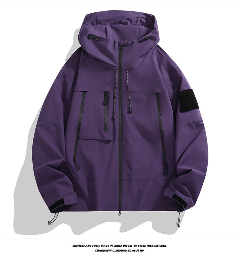Taktische Kapuzen-Shelljacke in Lila mit schwarzen Reißverschluss-Akzenten und einem taktischen Patch am Ärmel.