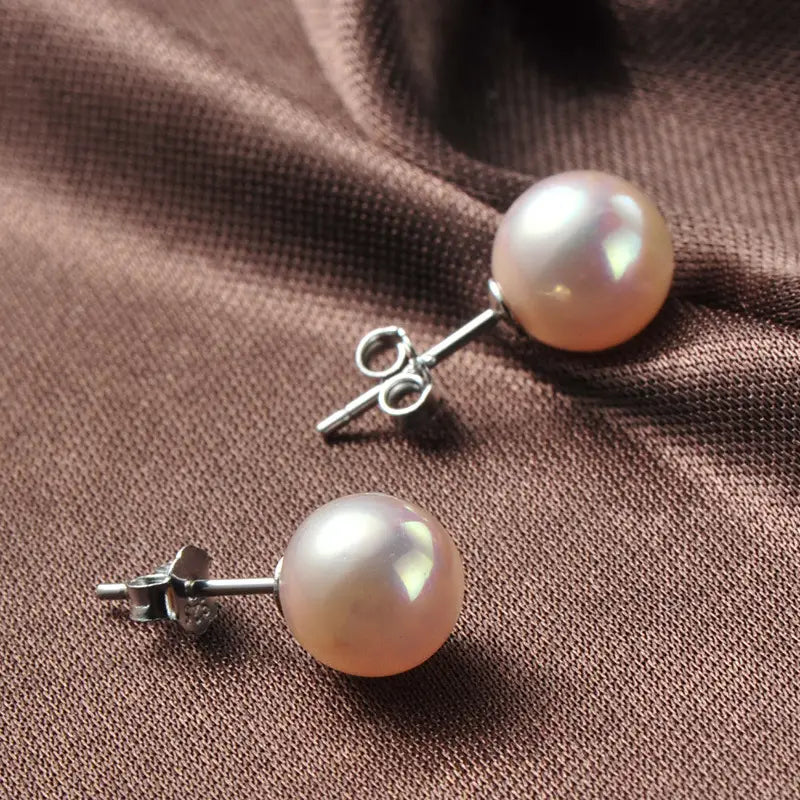 Sterling silver freshwater pearl stud earrings featuring delicate pink pearls with silver-toned posts and butterfly backings.