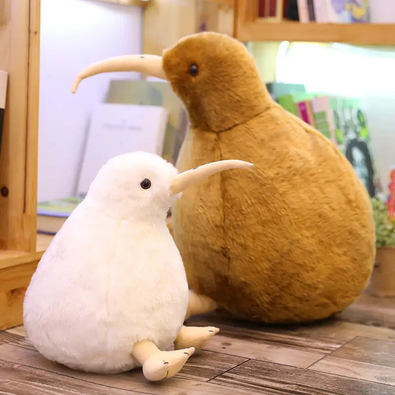 長いくちばしと黒い目を備えた、白と茶色のソフトなキウイバードのぬいぐるみ。柔らかなぬいぐるみ素材で作られており、キーチェーンとして設計されています。