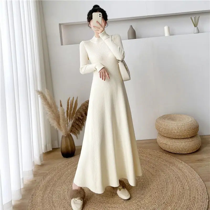 Robe midi en maille à manches longues couleur crème, à encolure haute et texture côtelée, mettant en valeur un style élégant et une matière confortable.