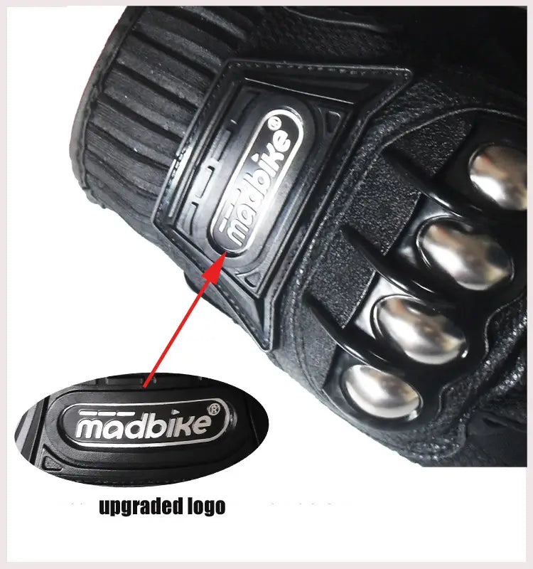 Black madbike alloy knuckle motorcycle riding glove with metallic silver finger protectors and textured leather-like surface shown from the back side.