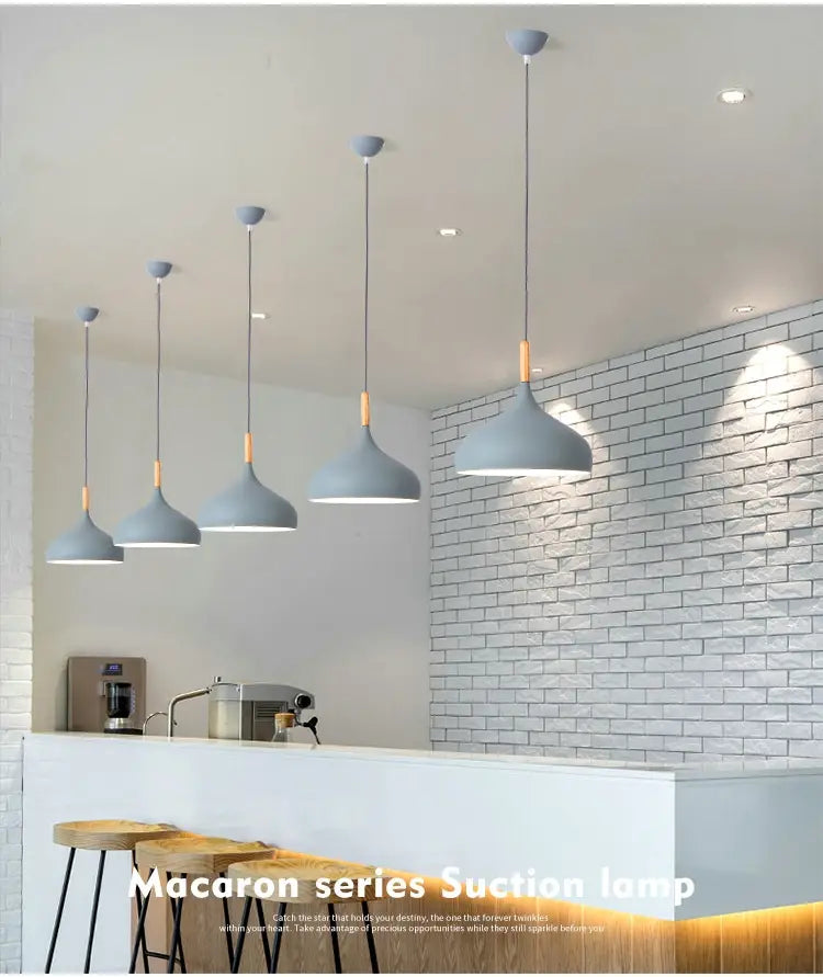 gray macaron series suction lamps with wooden accents hang from the ceiling in a nordic macaron led pendant light with wood accent design.