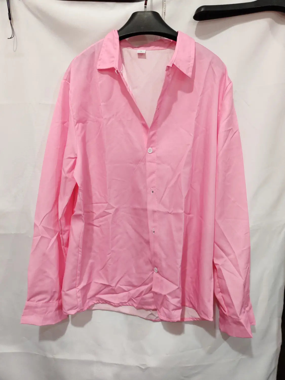Ein einfarbiges Slim-Fit-Leinenhemd für Herren in Soft Pink mit langen Ärmeln, Knopfverschluss vorne, klassischem Kragen und sorgfältig vernähten Bündchen.