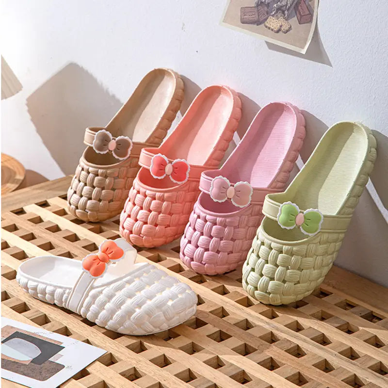 Pastel-colored woven bow slippers in beige pink and mint green made of pvc plastic designed as summer beach slide sandals.