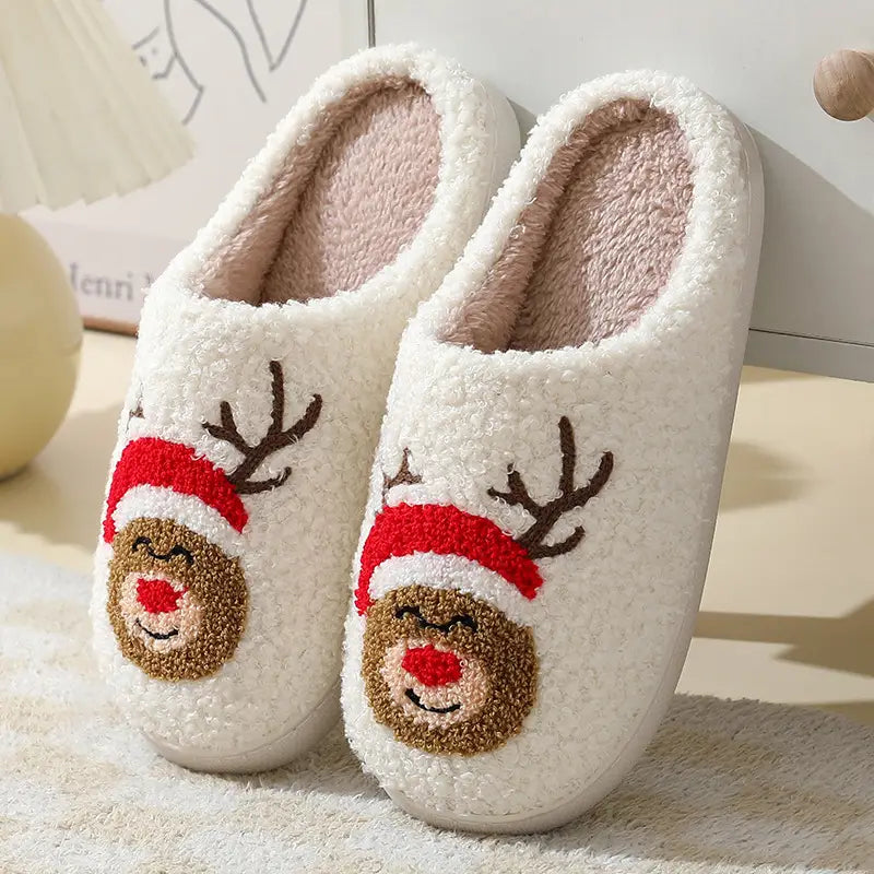white fluffy slippers featuring a cute reindeer face with brown fur red santa hat and black antlers from the festive embroidered santa and reindeer winter slippers collection