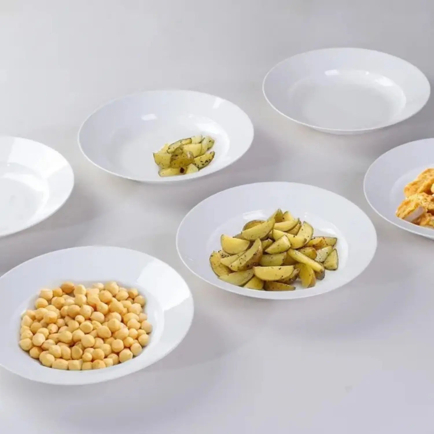 White ceramic dinner plates set of 6 with 9.5 inch bowls arranged with various food items.