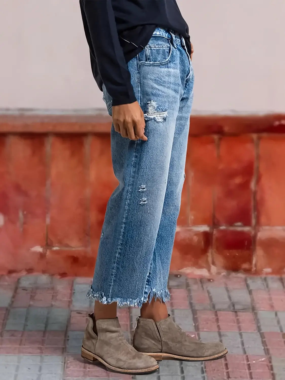 Jeans droits gris délavé déchirés confectionnés dans un denim à lavage moyen, avec ourlets effilochés et déchirures discrètes.