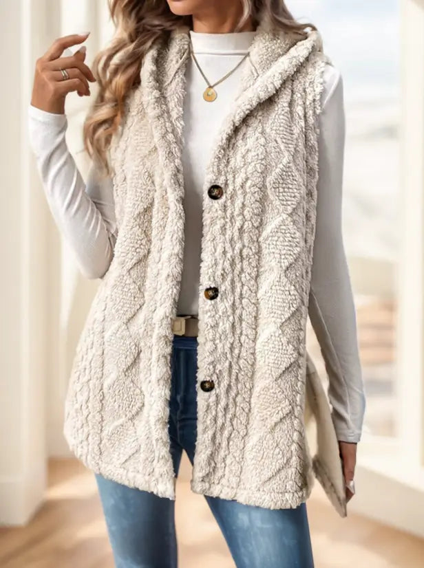Damen-Strickfleece-Weste mit Kapuze in Cremefarben mit Zopfmuster, Fleece-Material, Kapuze und Knopfleiste vorne.