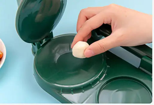 Dark green plastic dumpling maker with a round shallow pressing plate and hinged lid for manual dough pressing in a dumpling maker 3 in 1 tool.