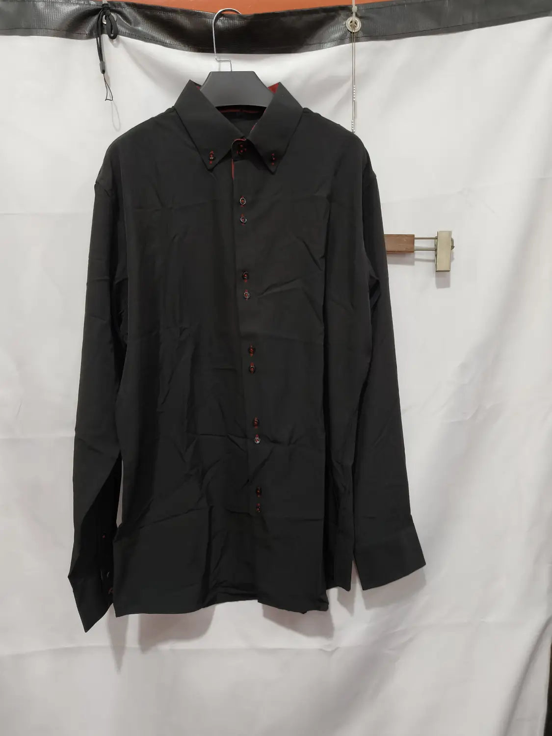 Chemise habillée stretch à empiècements contrastés noire à manches longues, col classique, devant boutonné, et coutures rouges discrètes le long de la patte de boutonnage.