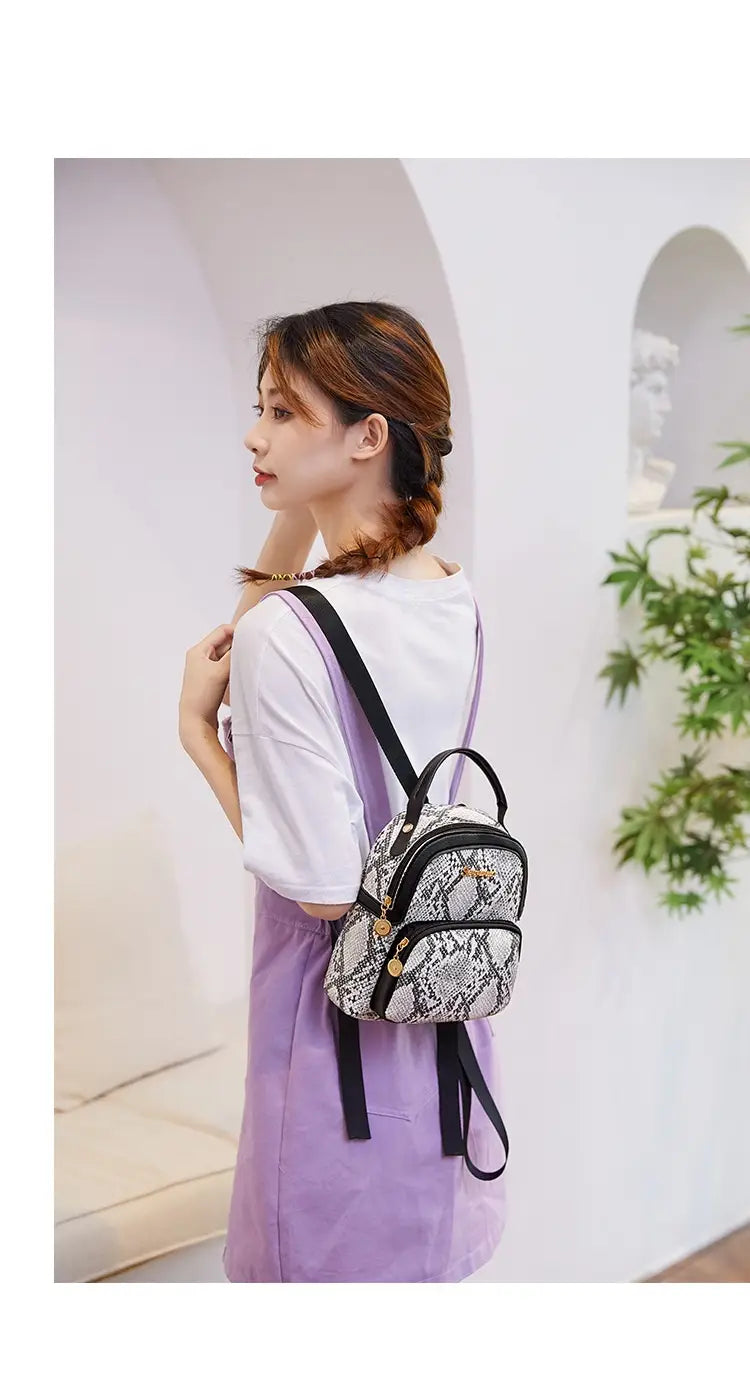 a small black and white snake-print mini backpack with gold-tone hardware in korean style