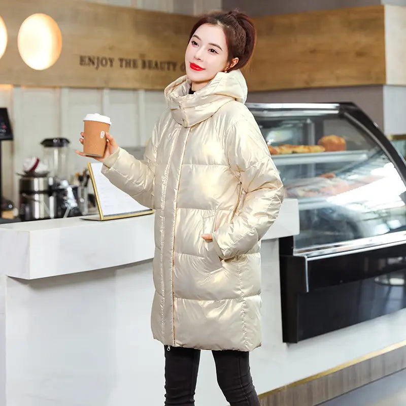A glossy black plus size puffer jacket with a shiny metallic gold quilted design and hood.