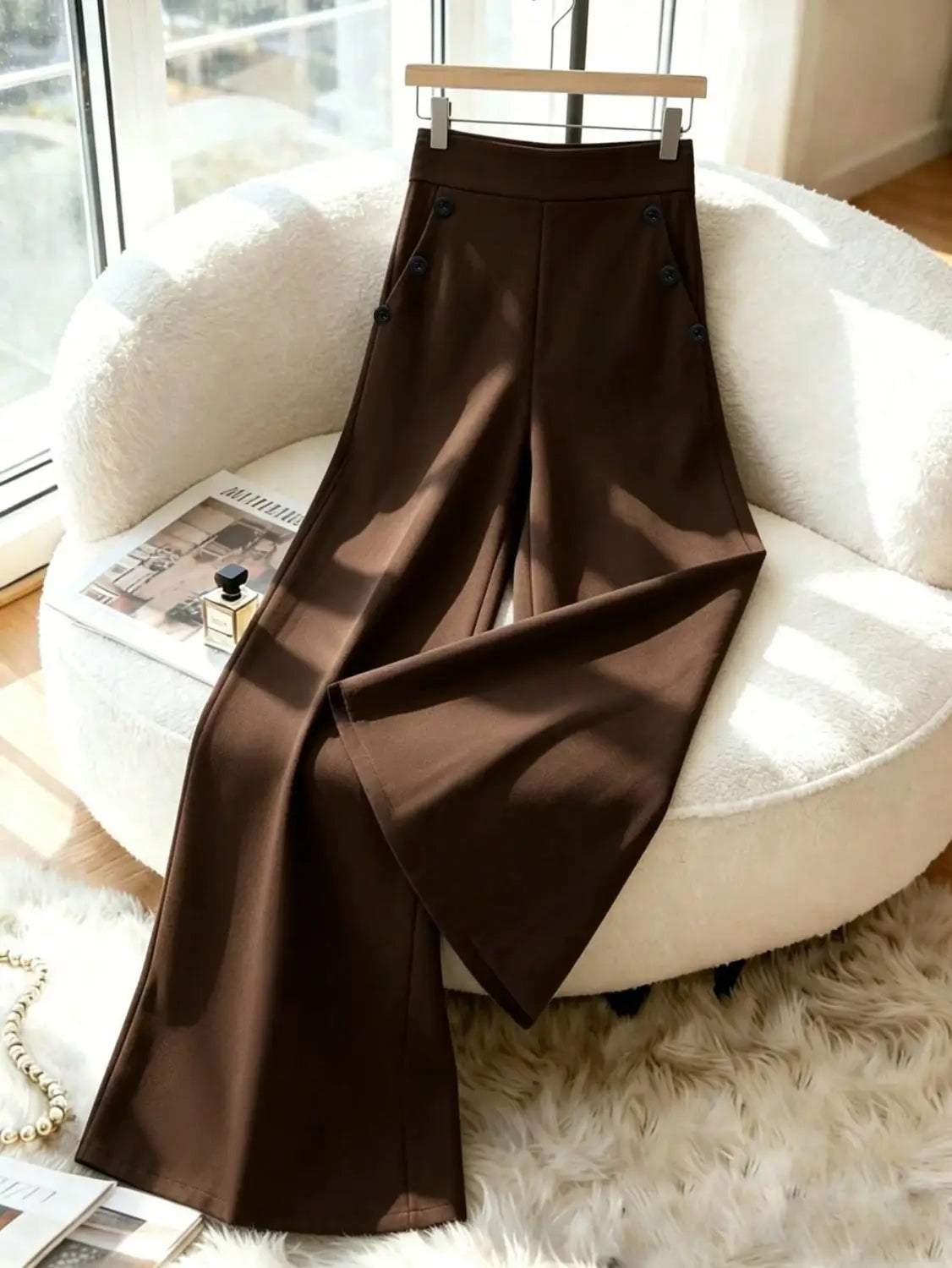 Pantalon ample taille haute marron avec une finition satinée élégante et des boutons décoratifs noirs sur les coutures latérales