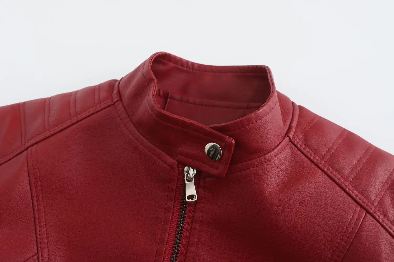 Veste motard en faux cuir rouge à col montant et fermeture éclair argentée conçue pour l’usage motocycliste