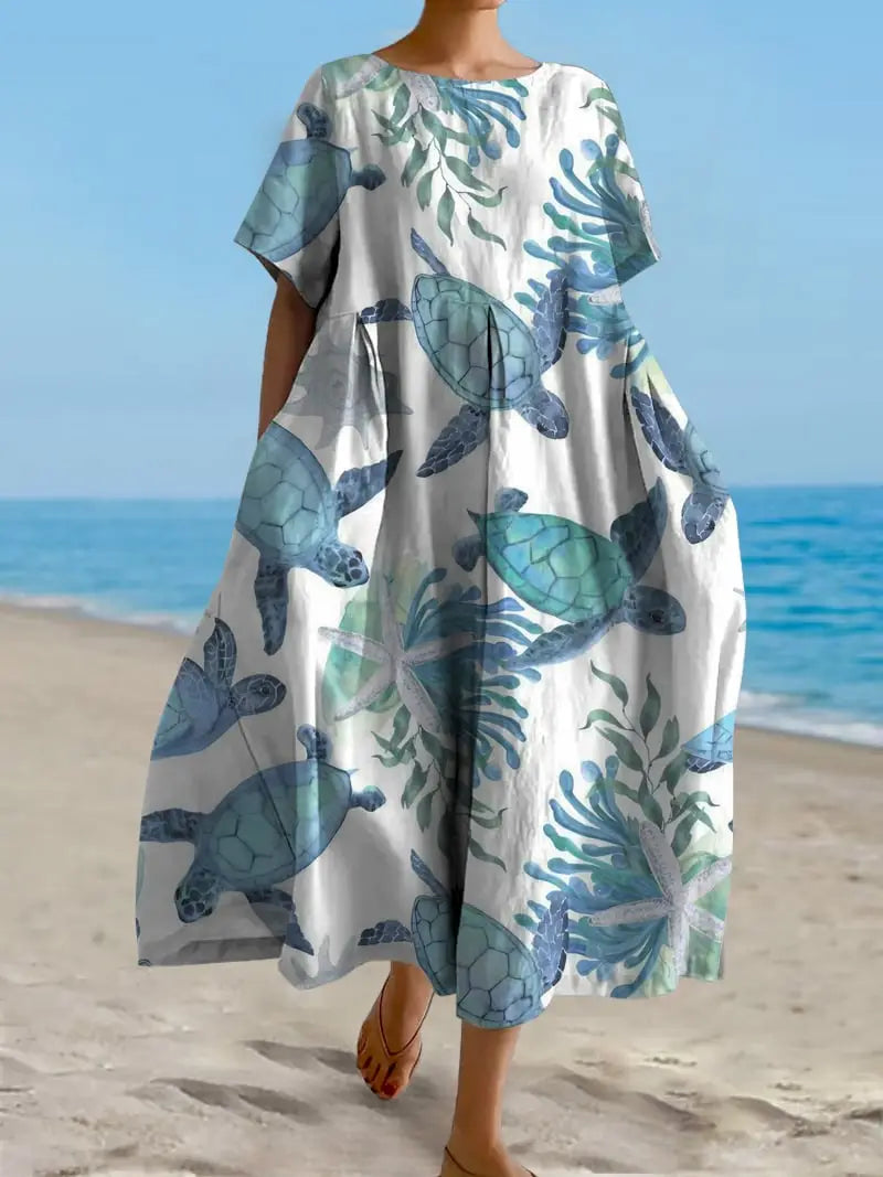 Robe longue en lin grande taille à coupe A à imprimé floral blanc fluide, présentant un motif ludique de tortues marines bleu et vert ainsi que des plantes aquatiques, réalisé dans un tissu léger