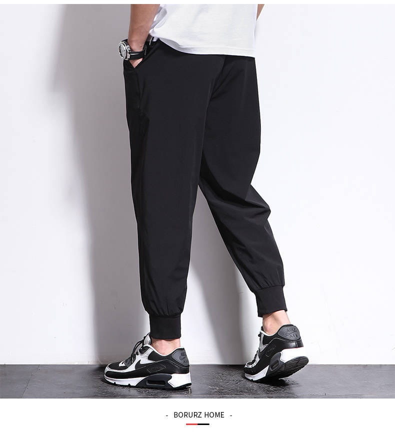 Pantalon de jogging athlétique pour hommes grande taille en noir, avec coupe décontractée et poignets élastiques, conçu pour le confort et le port décontracté.