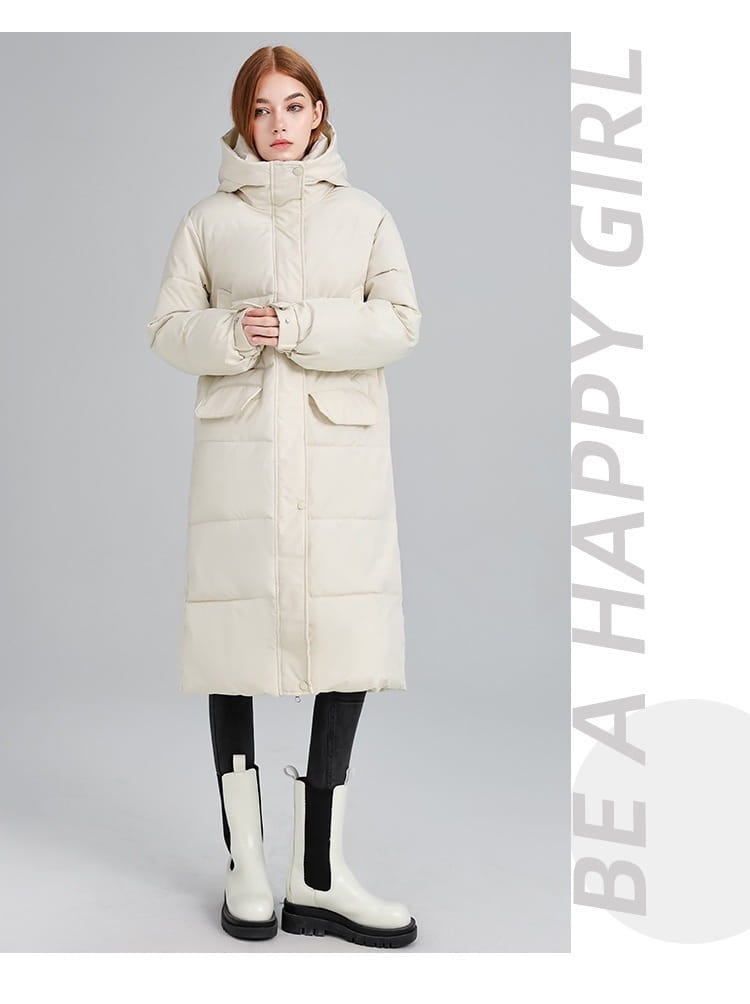 Manteau long matelassé à capuche pour femmes de couleur crème, réalisé en tissu matelassé, avec des poches avant pour une utilisation par temps froid.