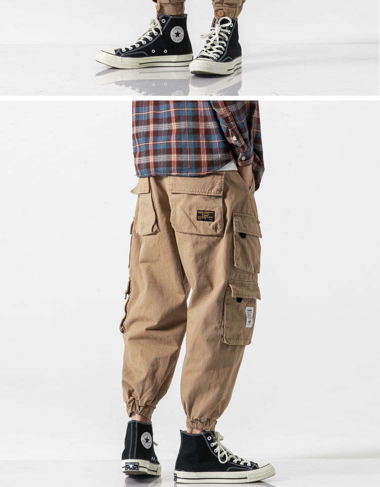 Pantalones cargo militares japoneses casuales color beige, de tiro cónico, con múltiples bolsillos y puños elásticos, combinados con zapatillas Converse negras tipo bota alta.