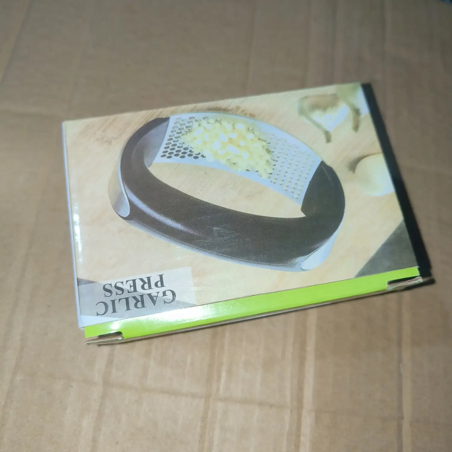 Presse-ail en acier inoxydable noir et argenté, conception manuelle ergonomique et surface de râpage perforée pour un hachage efficace.