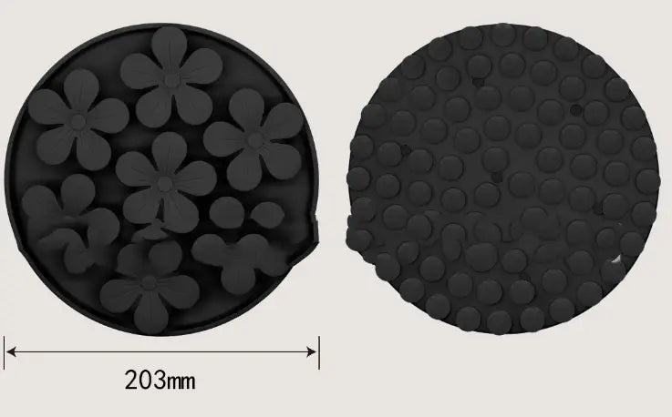 Tapis à lécher en silicone noir circulaire, avec des indentations en forme de fleurs en relief d’un côté et un motif de points texturés à l’arrière, conçu pour l’alimentation lente et l’enrichissement