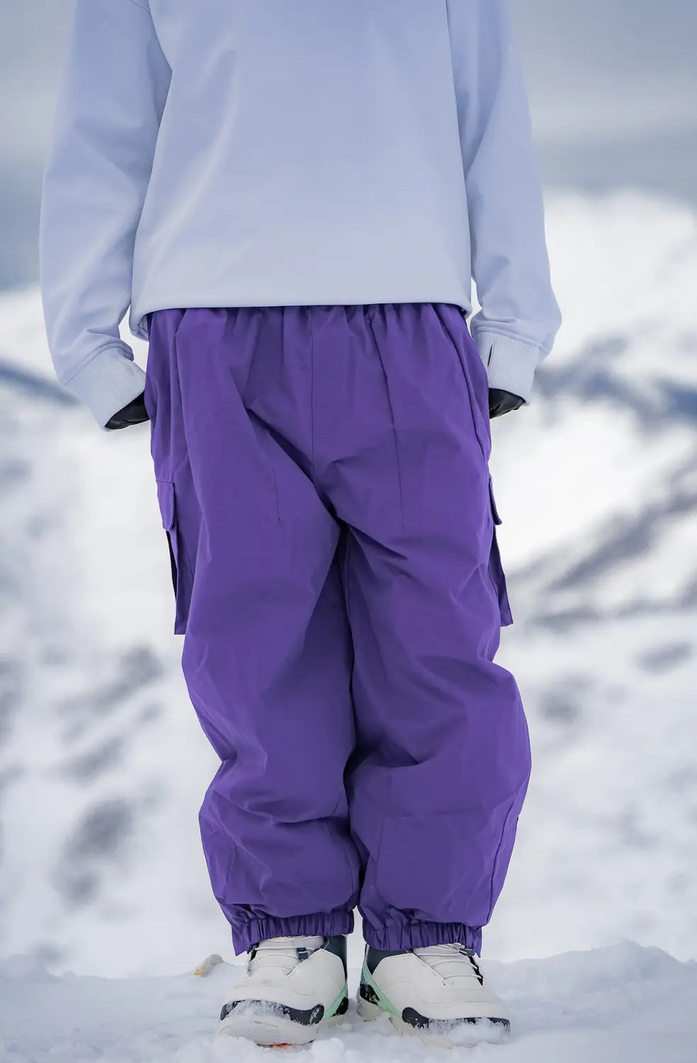 Purple winter outdoor loose ski cargo snow pants with elastic cuffs and side pockets for outdoor winter activities.