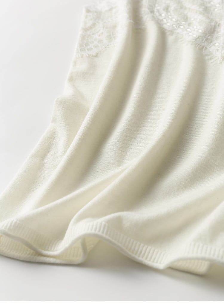 Cream-colored knit camisole top with delicate lace trim along the top edge.