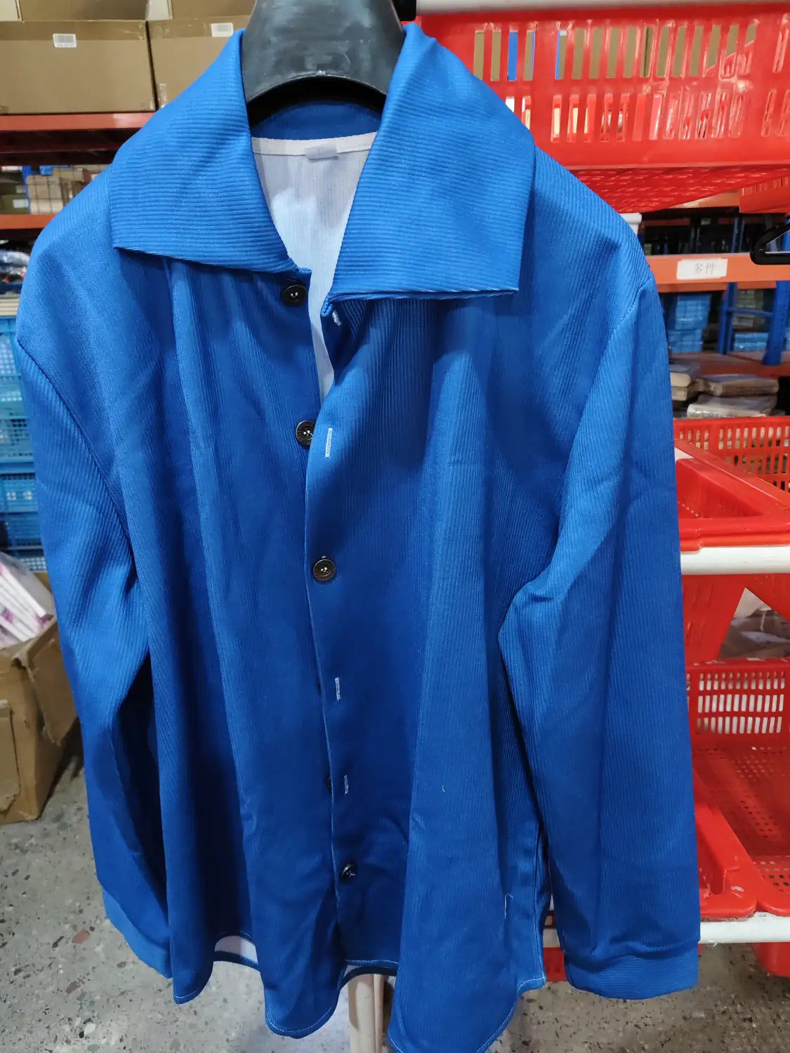 Cardigan boutonné en maille pour femmes avec une coupe ample et décontractée, assorti à une chemise boutonnée en velours côtelé bleu vif, dotée d’un col structuré et de boutons brun foncé.
