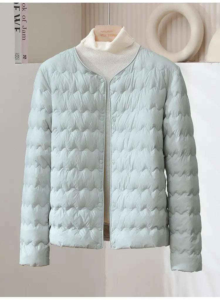 Light blue quilted puffer jacket with soft padded texture and button closure featuring a ruffled crew neck.