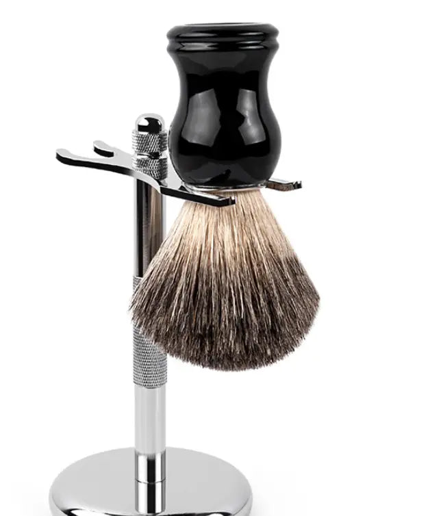 Black ceramic shaving bowl with silver-toned metal stand and badger hair shaving brush featuring a black ceramic handle and dense natural bristles in gradient brown.